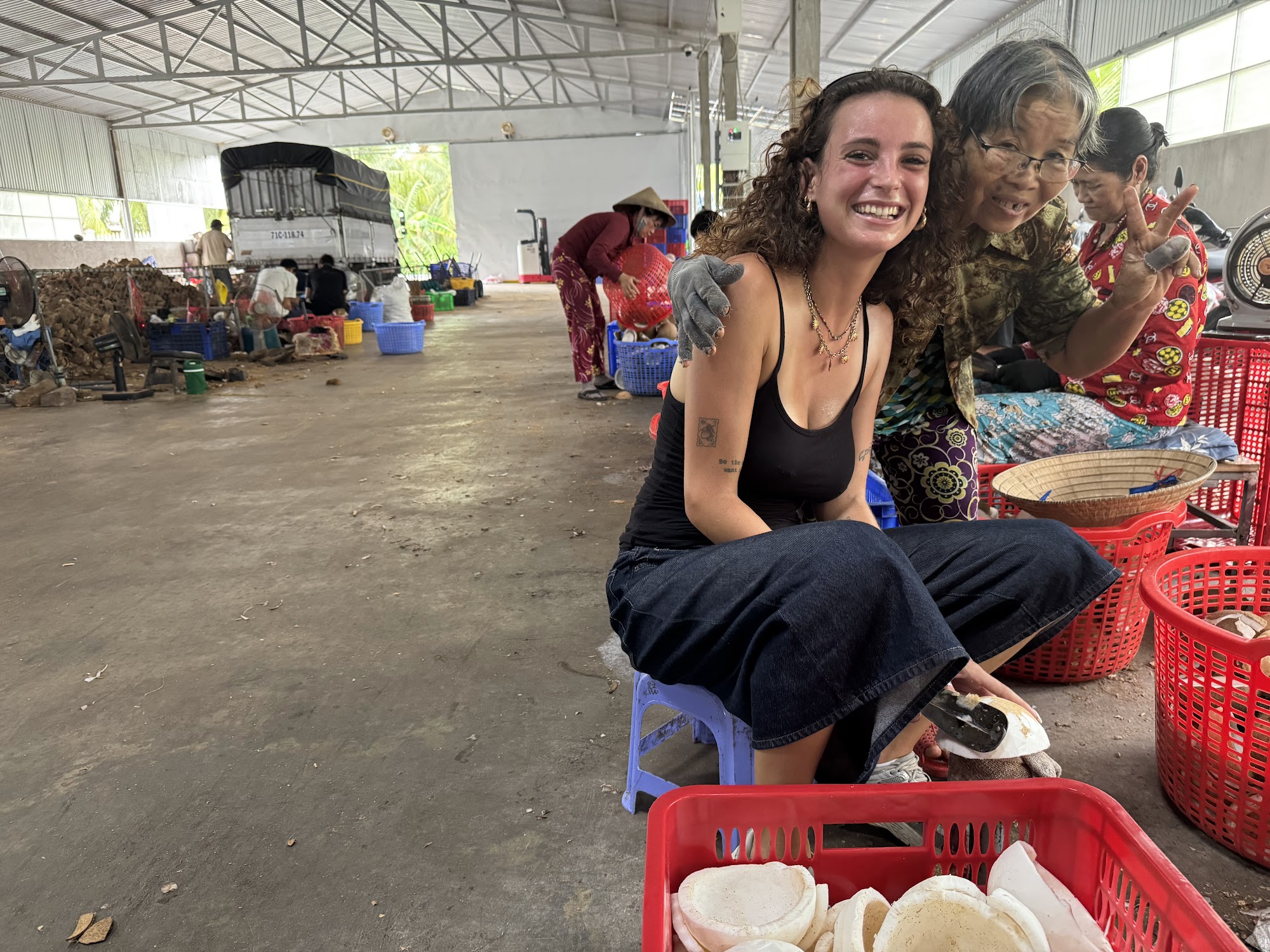 A traveler sitting with a local coconut worker at a village cooperative