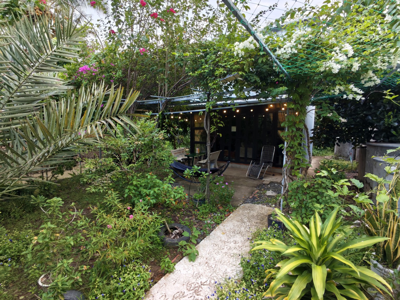 Independent Duplex Cabin surrounded by flowering tropical gardens at Coco Happy Farm in Ben Tre