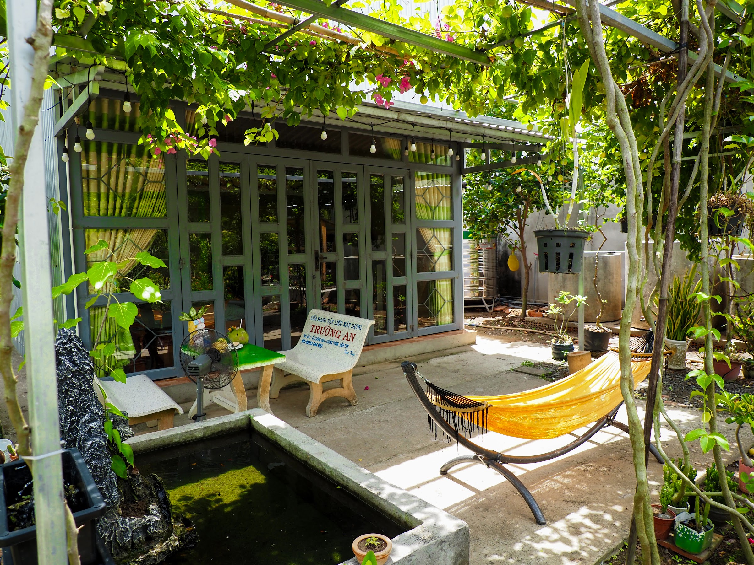 A small guest cabin and hammock in a tropical garden
