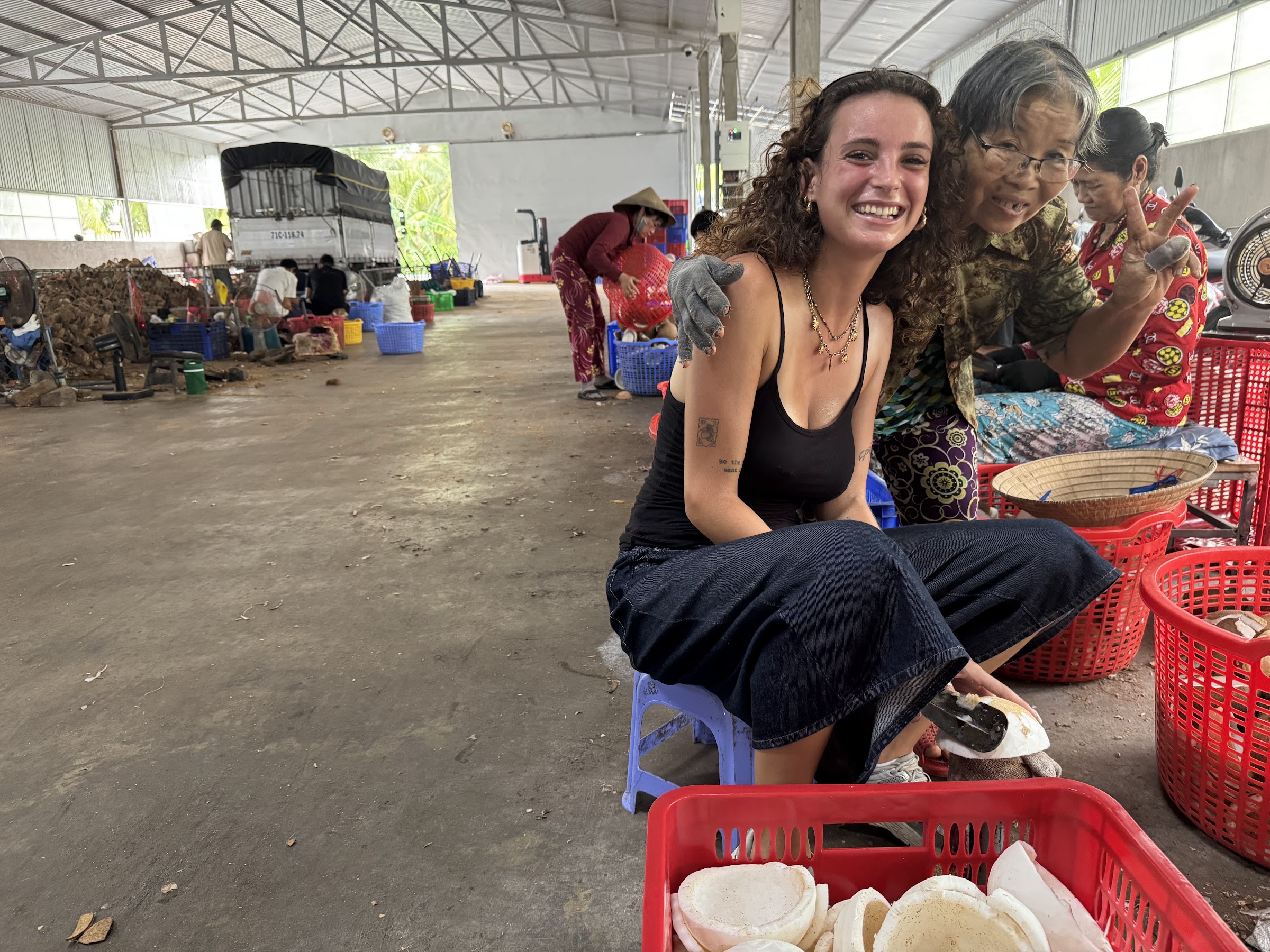 A visitor meeting a worker at a coconut-processing workshop in Ben Tre
