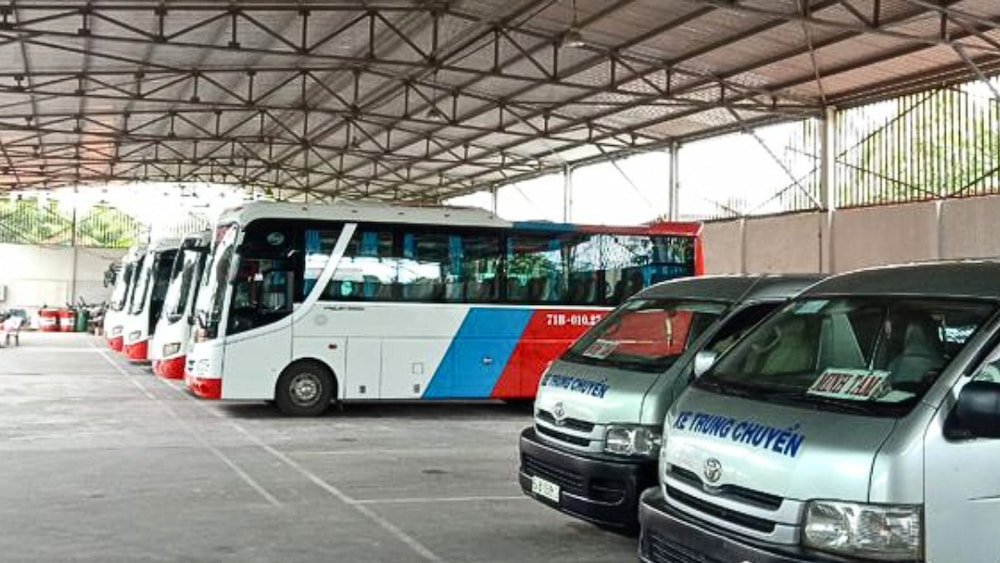 Minh Tâm buses and local transfer vans at a bus station